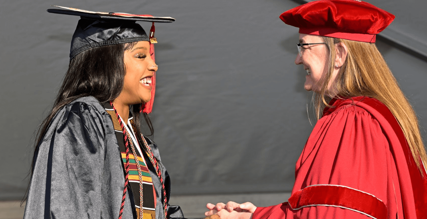 校长在毕业典礼上和一位留流苏的女毕业生握手