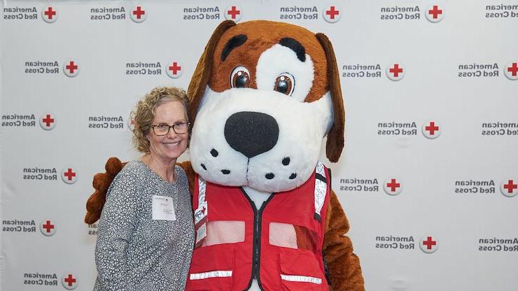 在一次活动中，护理校友兰迪·米勒与美国红十字会吉祥物弗雷德·克罗斯合影. 米勒四十多年来一直在帮助这个社区. 图片由美国红十字会提供